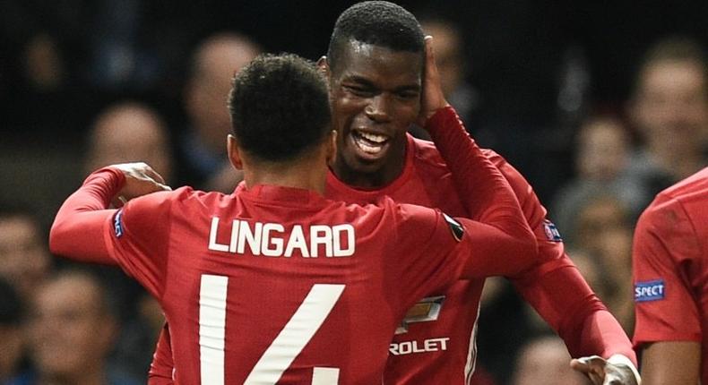 Manchester United's Paul Pogba (R) and Jesse Lingard (L) celebrate after Pogba scored their third goal against Fenerbahce in Manchester, on October 20, 2016.