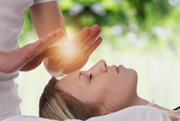 Woman having reiki healing treatment , alternative medicine concept.