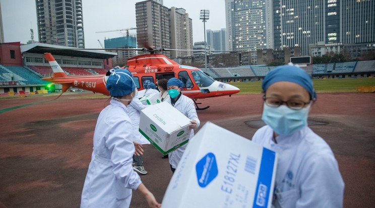 A képen a vuhani kórház védőöltözetet viselő dolgozói egészségügyi szállítmánya rakodnak ki egy helikopterből / Fotó: MTI/EPA/COSFOTO/YFC