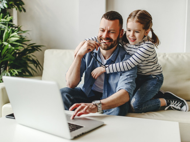 Ojciec z córką pracuje przy komputerze. Home office