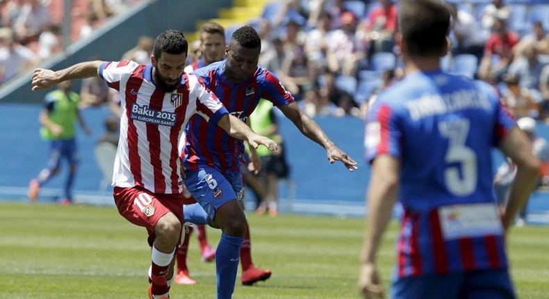 Atletico Madrid's Arda Turan (L) and Levante's Kalu Uche fight for the ball during their Spanish first division soccer match at the Ciudad de Valencia stadium in Valencia, Spain, May 10, 2015. REUTERS/Heino Kalis