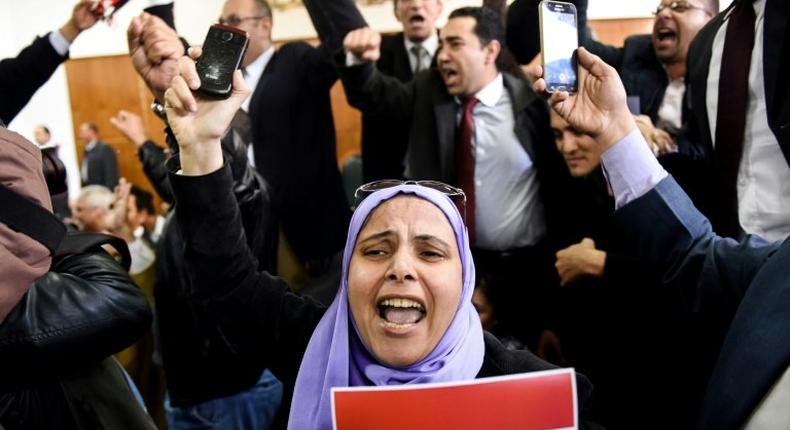An Egyptian woman holds a national flag scrawled with the words Tiran and Sanafir after the High Administrative Court upheld a ruling voiding an agreement to hand over the two Red Sea islands of Tiran and Sanafir to Saudi Arabia