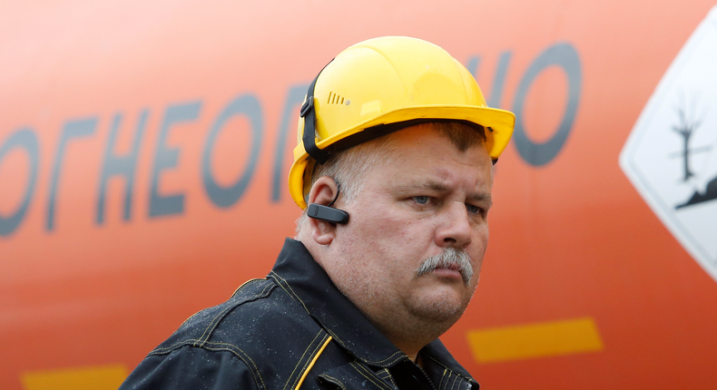 An employee stands in front of a fuel tanker at a Rosneft petrol station in Moscow, Russia, July 4, 2016.