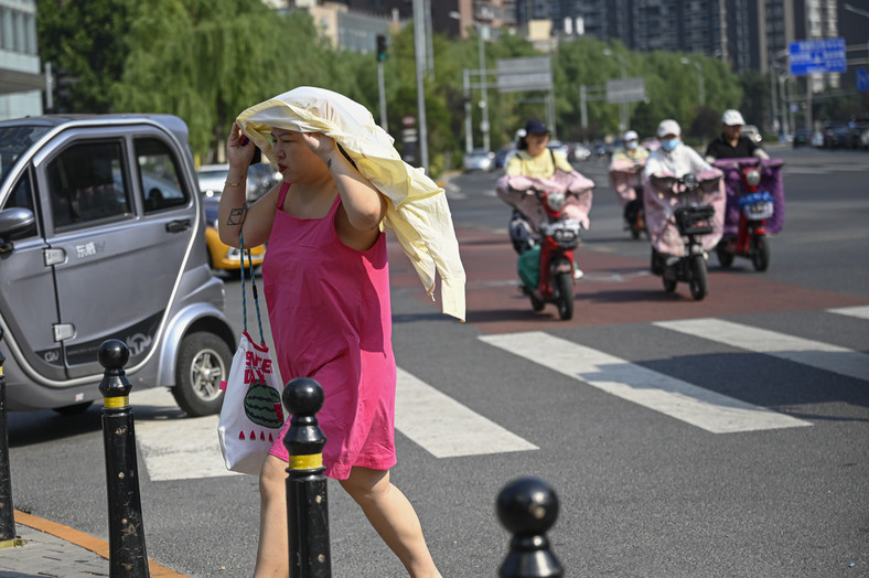 Kobieta próbuje radzić sobie z upałem w Pekinie. Chiny. Lipiec 2023 r.