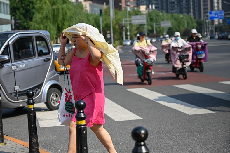 Kobieta próbuje radzić sobie z upałem w Pekinie. Chiny. Lipiec 2023 r.