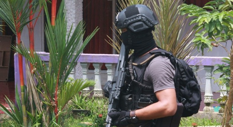 An Indonesian anti-terror police officer patrols the grounds of a house after a firefight erupted in South Tangerang, near Jakarta, on December 21, 2016