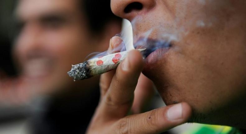 A man smokes marijuana during a demonstration in front of the Mexican Senate building in Mexico City on September 28, 2016