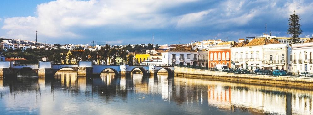 <strong>Odkryj najpiękniejsze miasto wybrzeża – Tavirę</strong>
<br></br>
Wspomniana wcześniej Tavira uchodzi za najpiękniejsze miasto Algarve. Znajduje się na terenie Parku Narodowego Rio Formosa. Z jednej strony otoczona przez piękne wybrzeże, z drugiej przez gaje pomarańczowe, drzewa migdałowe i figowce. Nie ma tam wielkich hoteli, za to pełno jest starych malowniczych kościółków. Architektura miasta to zaś mieszanka różnorodnych stylów. Odnaleźć można zarówno ślady starożytnych Fenicjan, wpływy barkowe, renesansowe i muzułmańskie.
<br></br>
Jednym ze znaków rozpoznawczych miasta jest średniowieczny most na rzece Gilao, wybudowany przez Maurów w XII wieku. Pozostałe ważne zabytki miasta to m.in. okazały XIII wieczny gotycki kościół Najświętszej Marii Panny (Igreja de Santa Maria do Castelo), renesansowy kościół Miłosierdzia (Igreja da Misericórdia), ruiny dawnego mauretańskiego zamku, wzniesiony pod koniec XIII wieku kościół Santiago (Igreja de Santiago) oraz liczne zabytkowe domy z charakterystycznymi trójkątnymi dachami (tesouro) i rzędami balkonów.
<br></br>
Jedno jest pewne – to miasto najlepiej poznawać niespiesznie. Jest w nim bowiem mnóstwo rzeczy, które potrafią przykuć naszą uwagę i pochłonąć nas całkowicie. Czy to chwila relaksu na jednym z sennych placów miejskich, która potrafi przeciągnąć się na cały dzień, filiżanka kawy w jednej z magicznych kawiarenek, spacer wśród zabytków czy błogi wypoczynek na pięknym wybrzeżu – każda chwila tam spędzona to celebracja wypoczynku – w najlepszym stylu. 
<br></br>
Miłośnikom kąpieli wodnych i słonecznych polecamy zwłaszcza Cabanę i Pedras del Rey - pobliskie małe wioski, które mogą poszczycić się cudownymi plażami. A szukając samotności warto udać się promem na Ilha da Tavira, na której znajdują się najpiękniejsze plaże na całym wschodnim Algarve, w tym słynna Barril – można tam wsiąść w pociąg turystyczny, który podczas ośmiominutowej przejażdżki umożliwi zobaczenie, między innymi, Parku Ria Formosa. 
<br></br>
<a  href=