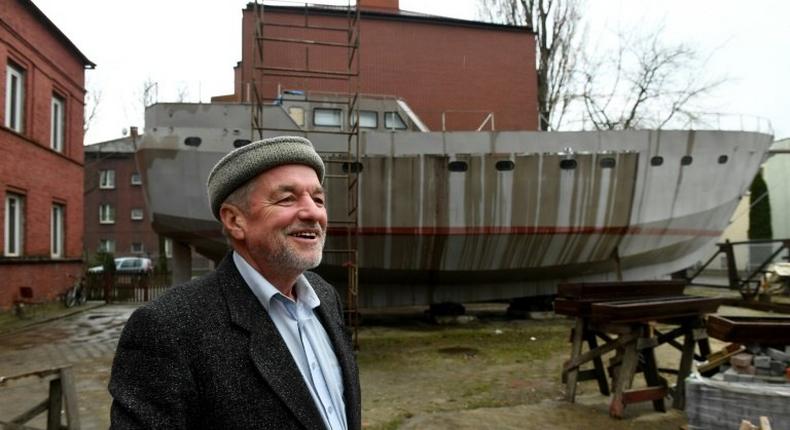 Ship Captain Waldemar Rzeznicki stands in front of a steel schooner named 'Father Boguslaw' under construction, at the courtyard of a homeless shelter run by Catholic Fathers, in Warsaw