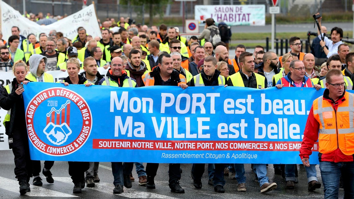 Harbor workers, storekeepers and residents march to participate in a human chain protest demonstration against the migrant situation in Calais