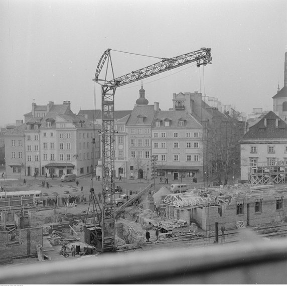 Odbudowa Zamku Królewskiego w Warszawie i wieszanie "wiechy" na odbudowanej części gotyckiej. Dźwig na placu budowy. W tle zabudowa Starego Miasta (1973 r.)