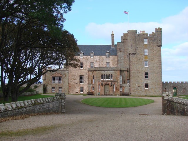 Ten zamek został zbudowany przez Jerzego, 4. hrabiego Caithness, który przekazał go swojemu drugiemu synowi, Williamowi Sinclairowi. Jest znany też pod nazwą Barrogill. Z jego początkami wiąże się tragiczna historia Williama i jego brata Johna. W 1952 r. królowa Elżbieta Matka zobaczyła zamek i kupiła go, mimo jego fatalnego stanu. Dzięki jej inwestycjom była możliwa renowacja zarówno zamku, jak i jego ogrodów. Królowa matka spędzała tam co roku trzy tygodnie sierpnia. Osiem lat temu ustanowiła fundusz powierniczy dla zamku. Dzięki niemu zamek jest w lecie otwarty dla publiczności.
  <br> Zdjęcie: Bill Henderson, CC BY SA 2.0