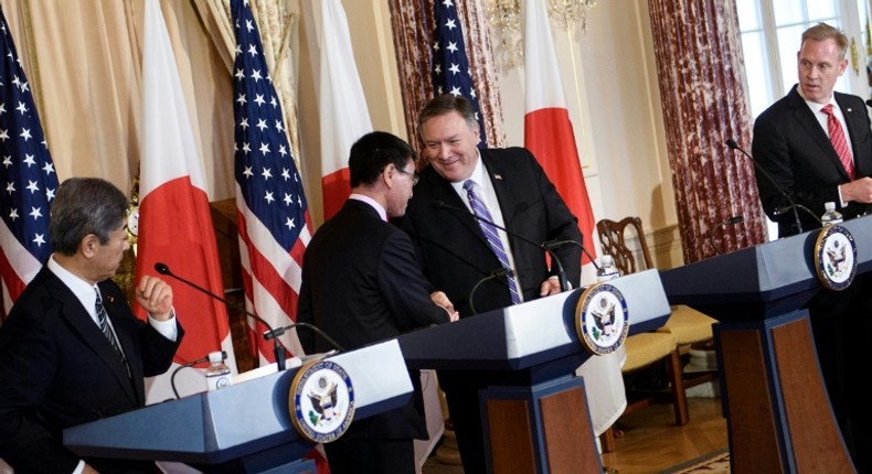 Secretary of State Mike Pompeo shakes hands with Japanese Foreign Minister Taro Kono as the allies' defense chiefs look on