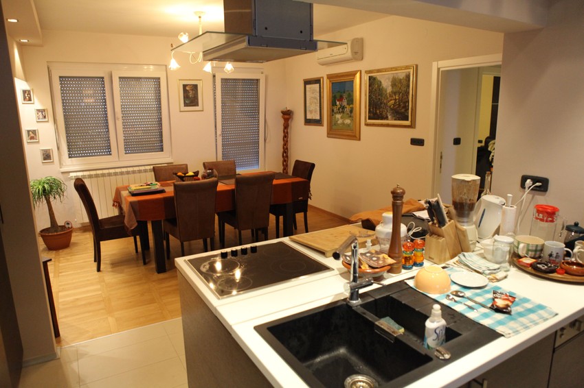 Kuhinja ima otvoreni šank i veliki sto za ručavanje