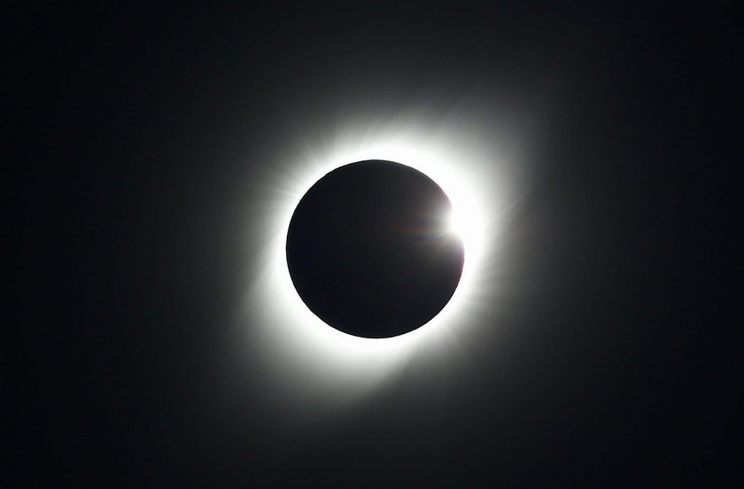 A mas wears a mask and a pair of eclipse glasses to observe a solar eclipse at La Serena