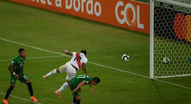 Peru's Jefferson Farfan (center) jumps over Bolivia's Marvin Bejarano to head home the decisive goal at the Copa America