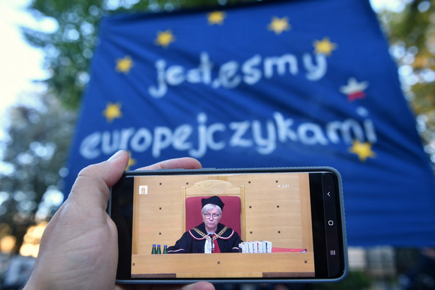 Prezes Trybunału Konstytucyjnego Julia Przyłębska podczas obrad oglądanych na ekranie telefonu przed siedzibą Trybunału Konstytucyjnego w Warszawie.