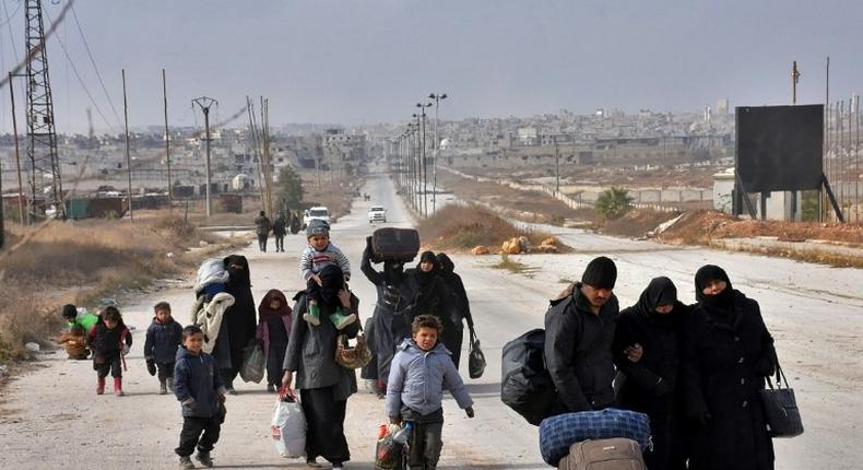 Syrian families freel from eastern Aleppo November 29, 2016 in Jabal Badro, as they walk towards government-controlled western Aleppo, as the Syrian government offensive to recapture rebel-held Aleppo continues