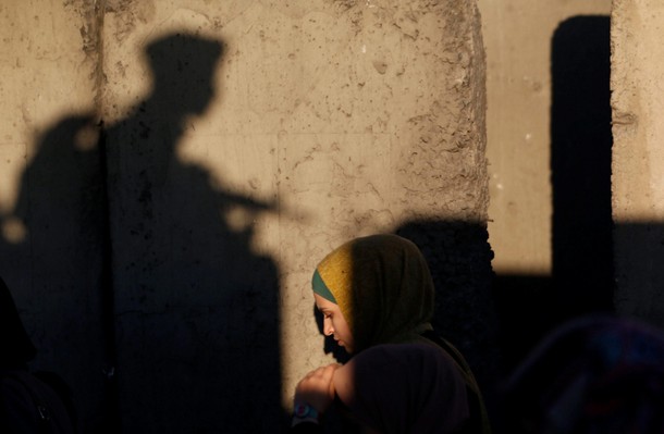 A Palestinian woman makes her way through Israeli Qalandia checkpoint to attend Friday prayer of the