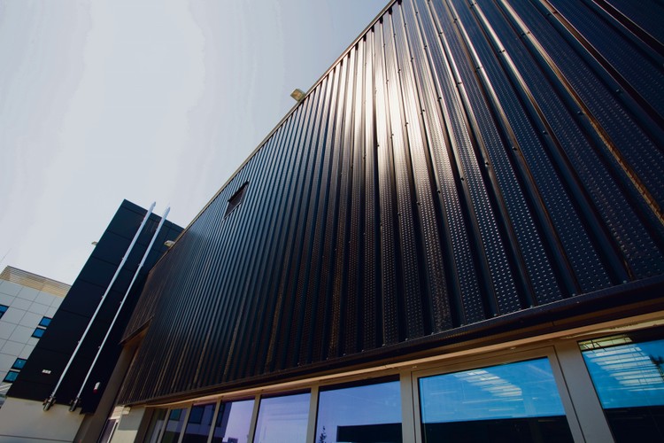 Obiekt wyposażono w najbardziej efektywną z dostępnych na rynku metodę pozyskiwania energii z odnawialnych źródeł, czyli system fototermiczny lub – innymi słowy – ścianę solarną. Pozwala ona na wykorzystanie podgrzanego powietrza powstałego w przestrzeni pomiędzy elewacją a zamontowanym na niej systemem blach perforowanych. Takie powietrze jest potem wtłaczane do budynku przez system wentylacyjny
<br>
System fototermiczny obniża koszty ogrzewania, a także chroni budynek przed niekorzystnymi warunkami pogodowymi. Ściana solarna jest odporna na odkształcenia, wilgoć i naprężenia termiczne