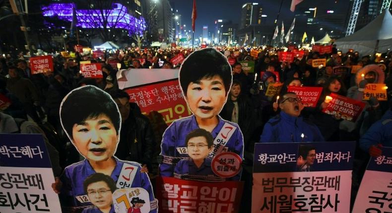 South Korean protesters carry portraits of President Park Geun-Hye during a protest demanding her immediate removal during a rally in Seoul, on January 7, 2017