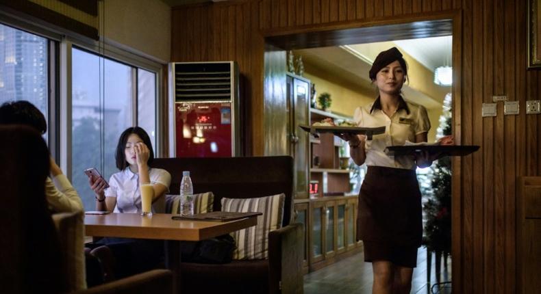 The Green Leaf Coffee Shop's 1970s-style decor is predominantly brown, and pictures of the Kimilsungia and Kimjongilia flowers named for North Korea's rulers are on show