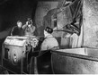 Filmowanie kopalni soli w Wieliczce. Kamerzysta filmuje górnika prowadzącego kolejkę z wagonikami, rok 1940
