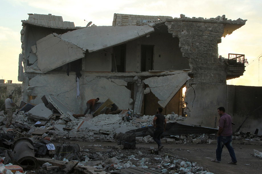 People inspect damage after an airstrike on the rebel-held town of Urm al-Kubra in Syria.