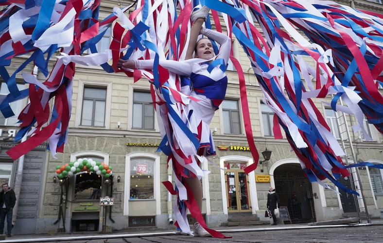 Tancerka występująca wśród wstęg w kolorach rosyjskiej flagi podczas obchodów rocznicy aneksji Krymu, Petersburg, 18 marca 2021 r.