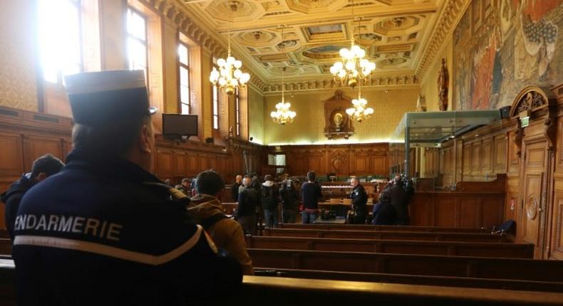 A gendarme looks towards reporters in the courtroom of a Special Court of Assizes at the Paris courthouse, prior to the start of the trial of a jihadist network known as the Cannes-Torcy cell, on April 20, 2017