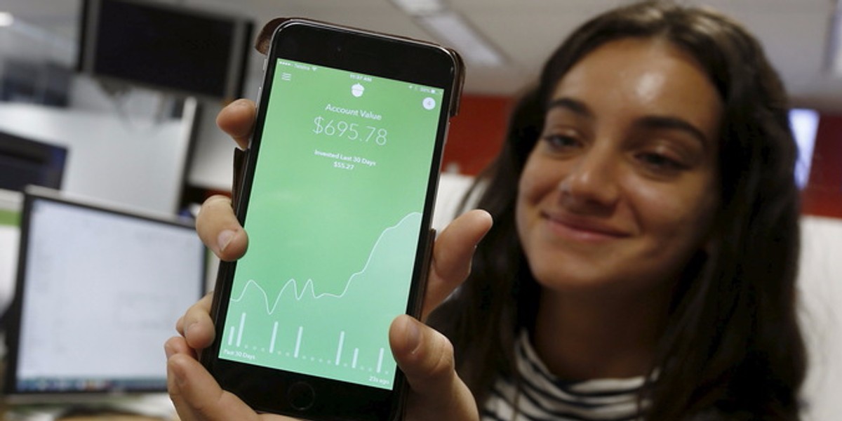 Madison Lucas, an employee of US-based technology company Acorns, demonstrates their smartphone-based app at the organization's Sydney headquarters in Australia.