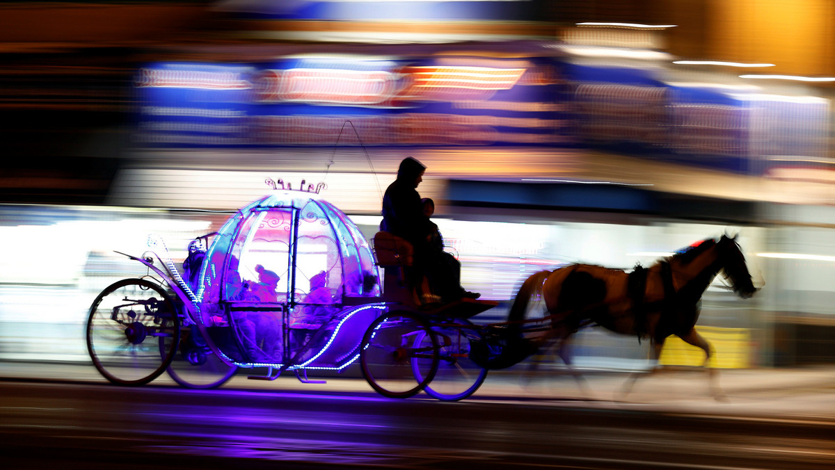 Children travel on an illuminated horse drawn carriage as they pass under the illuminations on the promenade in Blackpool, northern England