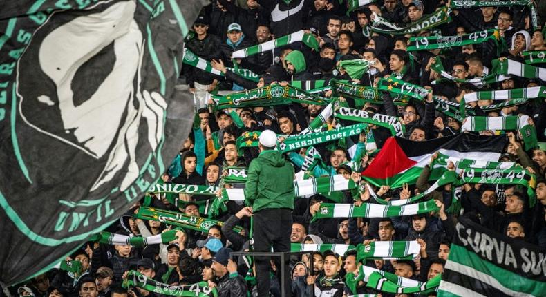 Supporters of Raja Club Athletic chant slogans and wave flags at a Moroccan football match between Raja and Mouloudia Oujda in January