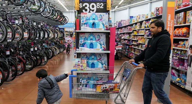 FILE PHOTO: A boy and his father walk through the toy section of Walmart on Black Friday, a day that kicks off the holiday shopping season, in King of Prussia, Pennsylvania, U.S., on November 29, 2019. REUTERS/Sarah Silbiger/File Photo