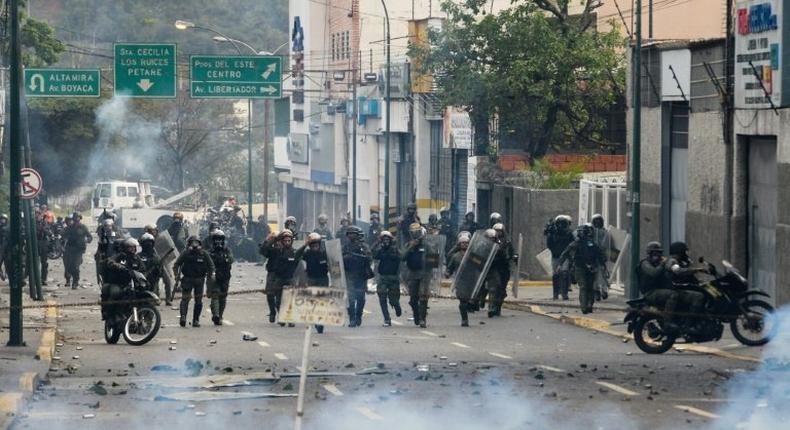 Riot police and opposition activists clash in Caracas on April 10, 2017 after Venezuela's political crisis intensified following the Supreme Court's ruling that curbed the powers of the opposition-controlled legislature