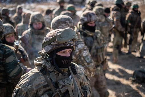 Grupa żołnierzy armii ukraińskiej czeka na kontynuację szkolenia taktycznego na obrzeżach Charkowa na Ukrainie