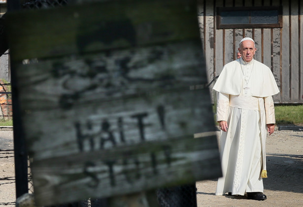 Papież Franciszek przechodzi przez bramę byłego niemieckiego, nazistowskiego obozu zagłady Auschwitz.