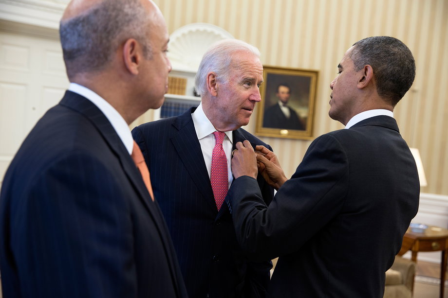 Obama adjusts Biden's American flag pin as they wait in the Oval Office with Jeh Johnson, prior to announcing Johnson as the nominee for Secretary of the Department of Homeland Security on Oct. 18, 2013.