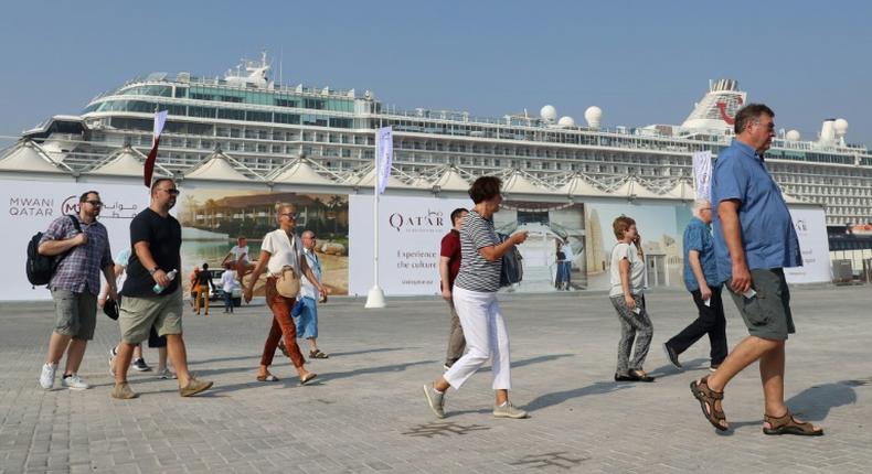 Tourists disembark at Doha Port's temporary passenger terminal