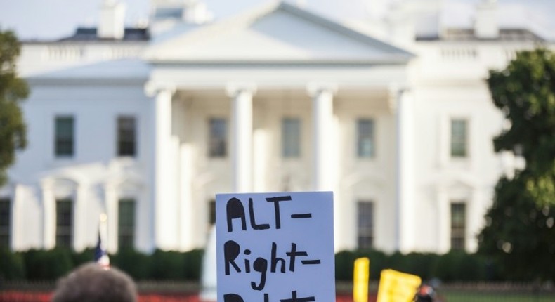 A demonstrator holds a sign in front of the White House during a vigil in response to the death of a counter-protestor in the August 12 Unite the Right rally in Charlottesville, Virginia