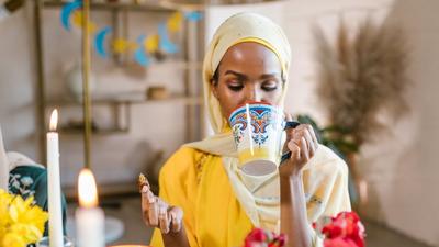 Woman in yellow hijab eating and drinking during Ramadan [Image Credit: RDNE Stock Project]
