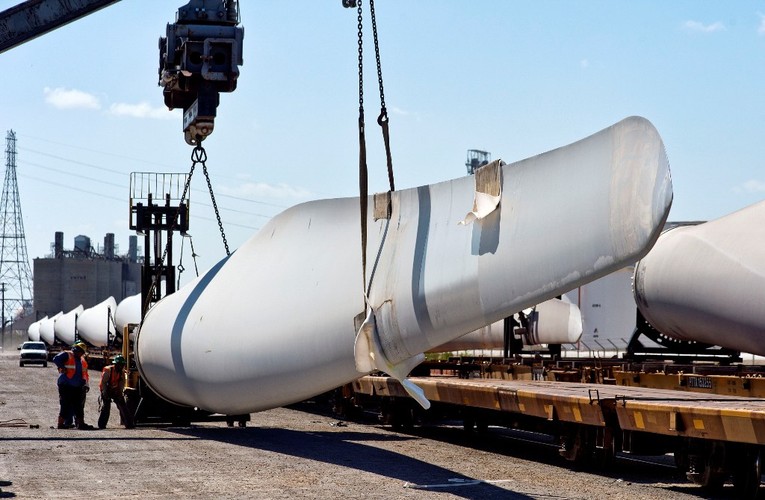 Transport turbiny wiatrowej, za pomocą dźwigów. Pracownicy ładują łopatę na platformę kolejową. 
Turbina stanowi główny element elektrowni wiatrowej, która składa się z wirnika zamontowanego na wysokiej wieży, połączonego z generatorem prądu. 
<br>
Ze względu na niewielką prędkość wiatrów wiejących przy powierzchni Ziemi, moc generowanego prądu może być zwiększana zarówno poprzez zwiększenie średnicy wirnika, jak i wysokości wieży.