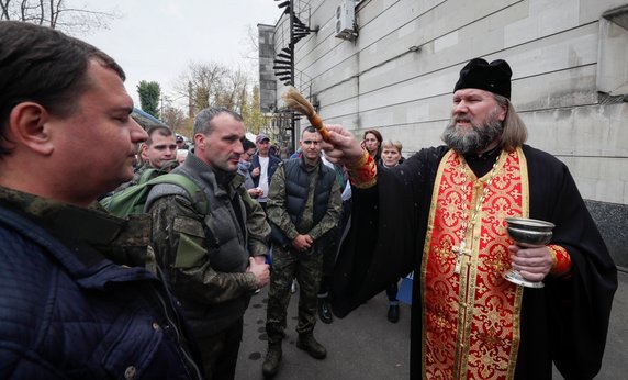 Prawosławny ksiądz błogosławi rosyjskich poborowych przed biurem rekrutacyjnym podczas częściowej mobilizacji wojskowej Rosji w Moskwie. 12.10.2022 r.