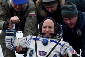 Ground personnel help U.S. astronaut Scott Kelly to get out of a Soyuz capsule shortly after landing