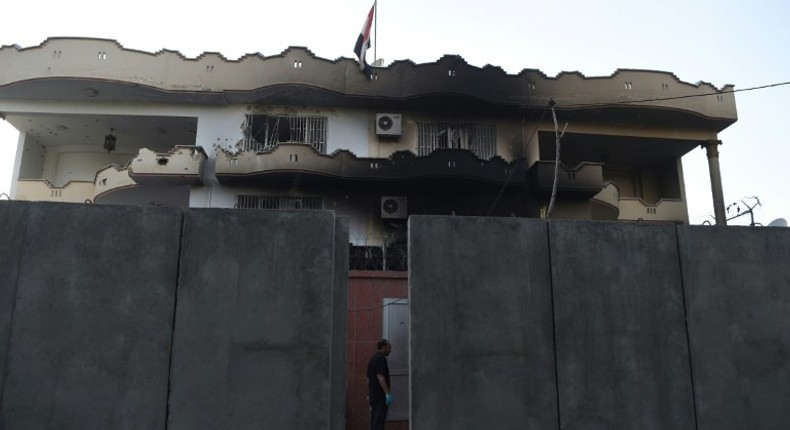 An Afghan security personnel stands at the entrance of the Iraqi embassy building after an attack in Kabul on Monday