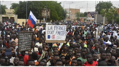 Protesters hold an anti-France placard during a demonstration on independence day in Niamey on August 3, 2023 [AFP]