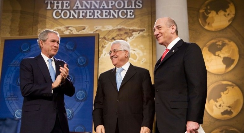 US President George W. Bush applauds then-Israeli prime minister Ehud Olmert (R) and Palestinian President Mahmud Abbas (C) at a peace conference on November 27, 2007