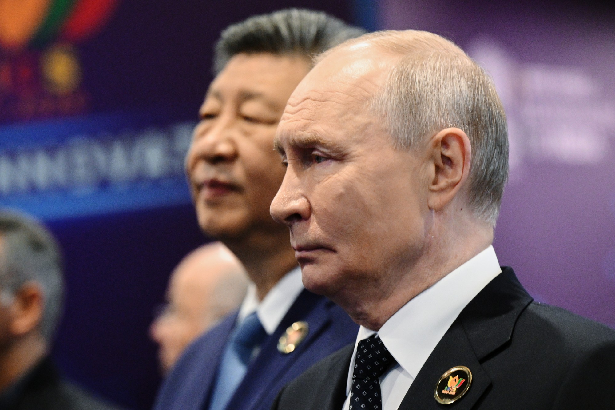 Ruský prezident Vladimir Putin a v pozadí čínsky prezident Si Ťin-pching. 