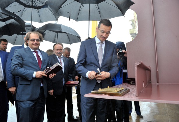 Wicepremier, minister rozwoju i finansów Mateusz Morawiecki (P), minister gospodarki i żeglugi śródlądowej Marek Gróbarczyk (L), prezes zarządu Morskiej Stoczni Remontowej "Gryfia" S.A. Marek Różalski (C) podczas uroczystości położenia stępki pod budowę promu pasażersko-samochodowego.