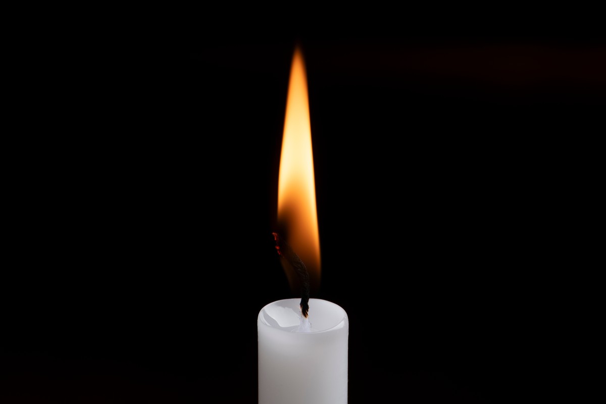 A,Candle,Flame,Glowing,Against,A,Dark,Background